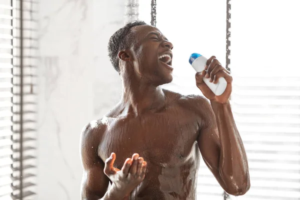 Homem Africano Nu Cantando Segurando Garrafa De Shampoo Tomando Chuveiro Interior — Fotografia de Stock