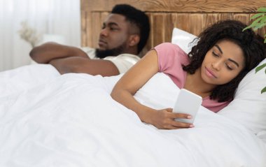 Genç siyahi kadın sevgilisinin yanında sohbet ediyor.