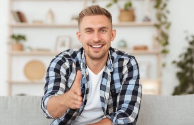 Kamera karşısında el sıkışmak için kendine güvenen bir adam.