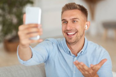 Video görüşmesi için cep telefonu kullanan mutlu adam.