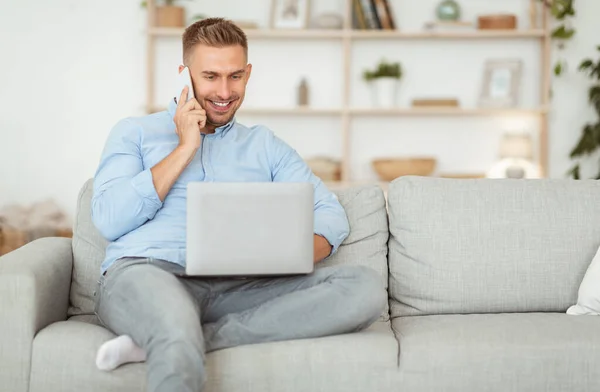 Retrato de un chico sonriente exitoso usando el teléfono y la PC — Foto de Stock