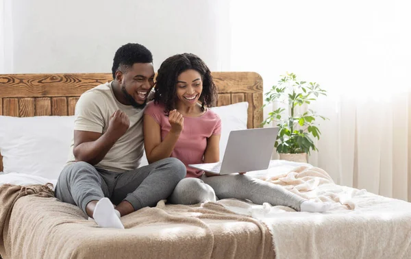 Emotionales afrikanisch-amerikanisches Paar blickt auf Laptop-Bildschirm und schreit — Stockfoto