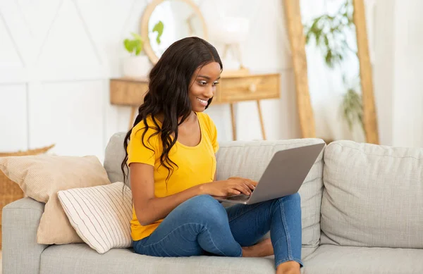 Wspaniała czarna pani studiuje lub pracuje online z domu, za pomocą laptopa — Zdjęcie stockowe