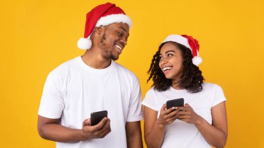 Noel Baba Şapkalı Çift Akıllı Telefon Kullanıyor Noel Uygulaması, Sarı Arkaplan
