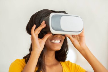 Günlük yaşamda gelecek teknolojileri. Mutlu siyah bayan VR kulaklık takıyor ve siber uzay keşiflerinin tadını çıkarıyor.