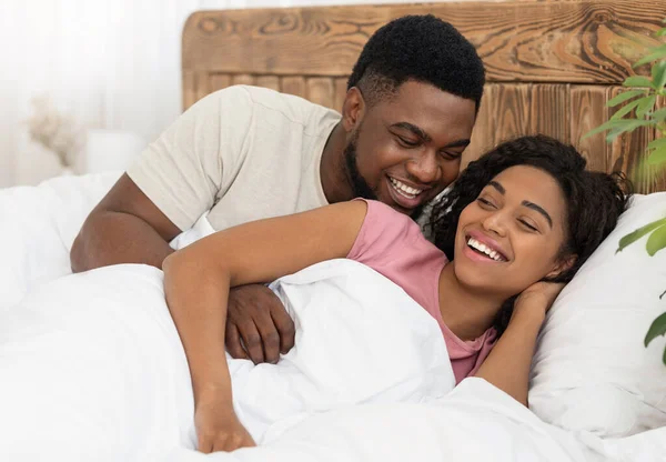 Szczęśliwy romantyczny czarny para przytulanie w łóżko — Zdjęcie stockowe