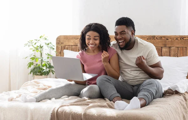 Emocionada familia negra expresando felicidad, mirando la pantalla del portátil —  Fotos de Stock