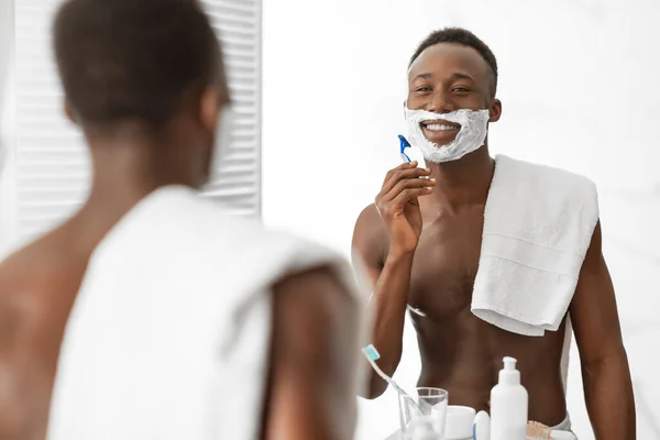 Shirtless African Guy Rasieren Gesicht Stehen In der Nähe Spiegel Im Badezimmer — Stockfoto