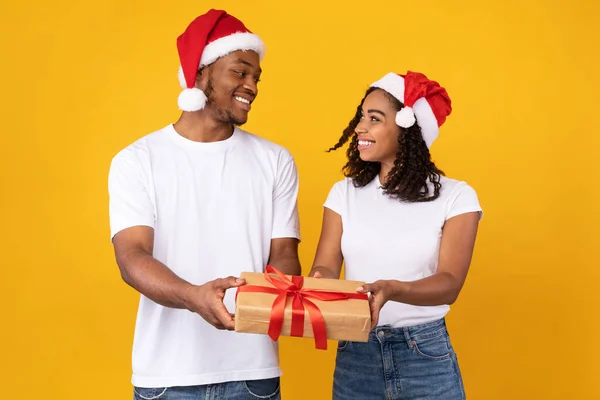 African American Ζευγάρι Προσφέροντας Χριστουγεννιάτικο δώρο Posing σε κίτρινο φόντο — Φωτογραφία Αρχείου