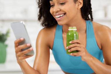 Siyahi Kadın Meyve Smoothie ve Cep Telefonu Kullanıyor