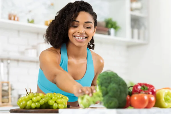 Счастливая молодая черная модель готовит овощной салат — стоковое фото