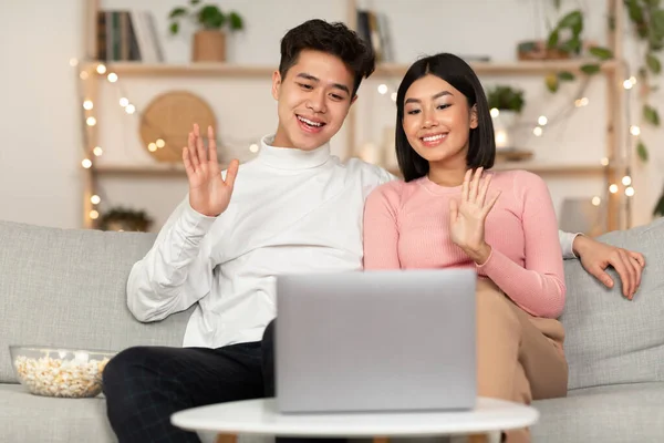 自宅でノートパソコンでビデオ通話を作る陽気な中国のカップル — ストック写真