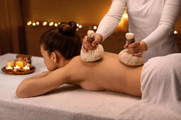 Terapeuta de spa haciendo masaje corporal con bolas de compresa a base de hierbas — Foto de Stock