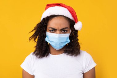 Mutsuz Afrikalı Kadın Maskeli ve Noel Şapkalı, Sarı Arkaplan