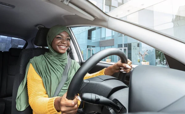 Stadsrit. Gelukkig glimlachen zwarte moslim dame in hoofddoek rijden moderne auto — Stockfoto