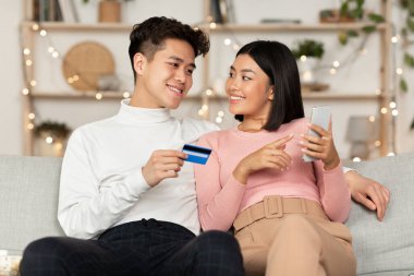 Çevrimiçi Asyalı Çift Alışveriş Kredi Kartı ve Telefonu Kullanıyor