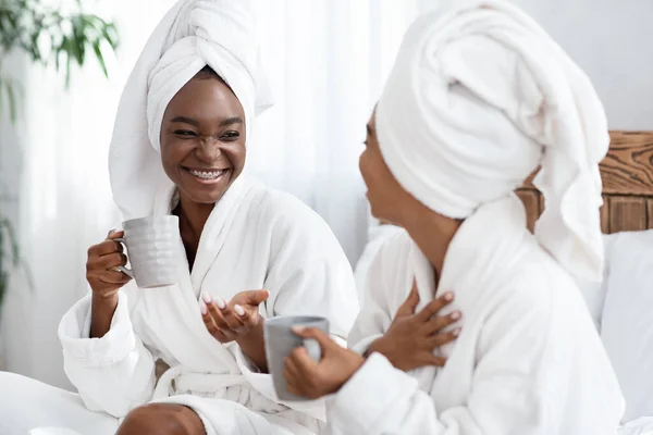 Deux joyeuses femmes noires plaisantant en buvant du thé — Photo