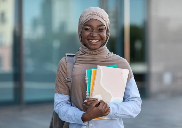 Oktatás a muszlim nőknek. Mosolygó afrikai iszlám női főiskolai hallgató pózol szabadban — Stock Fotó