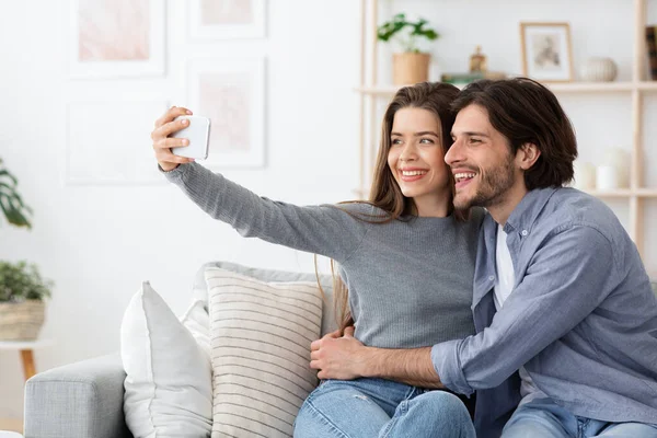 Θετικό νεαρό ζευγάρι ερωτευμένο να βγάζει selfie στο σπίτι — Φωτογραφία Αρχείου