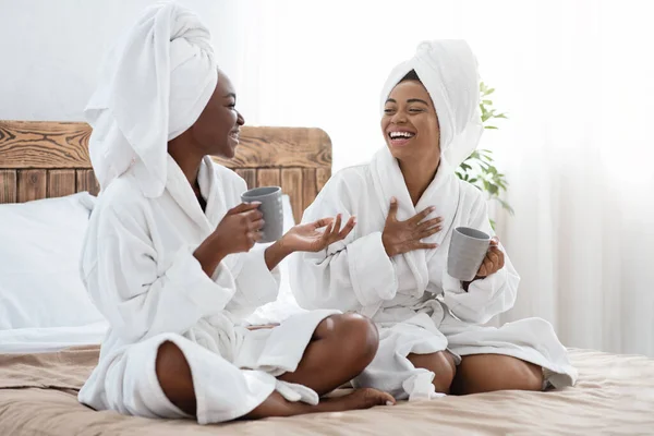 Vrolijke zwarte dames drinken koffie en lachen — Stockfoto