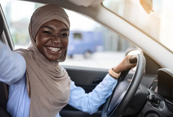 Auto Selfie. Alegre mujer musulmana negra tomando autorretrato en su nuevo auto — Foto de Stock