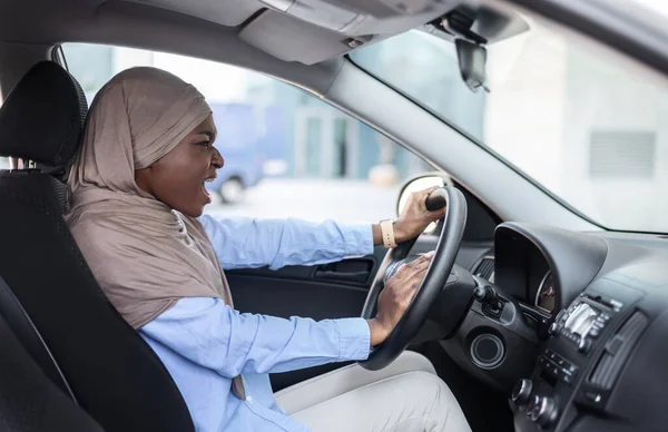 Boos zwart moslim zakenvrouw rijden auto, vast in het verkeer, emotioneel piepende hoorn — Stockfoto