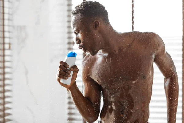 Hombre afroamericano tomando ducha canto canción celebración champú interior — Foto de Stock