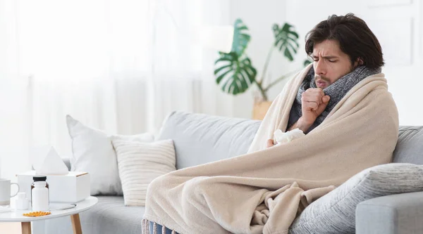 Sjuk man sitter på soffan i vardagsrummet och skrattar — Stockfoto