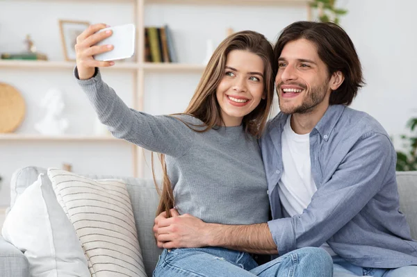 Retrato de jóvenes amantes tomando selfie en smartphone —  Fotos de Stock