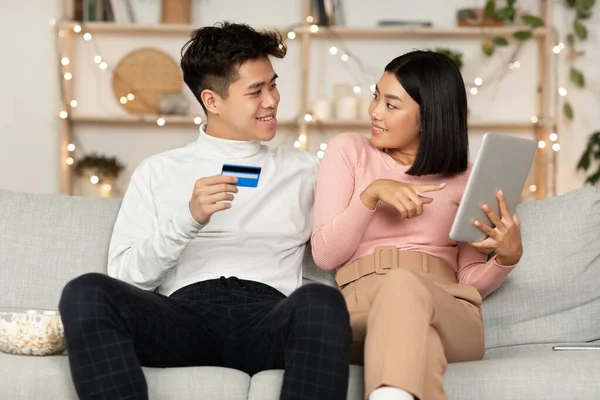 Korejský pár Nakupování on-line pomocí digitální tablety sedí doma — Stock fotografie