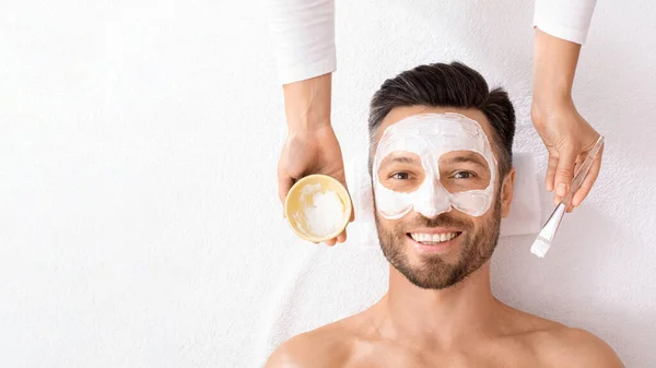 Top view of smiling man with face mask on white