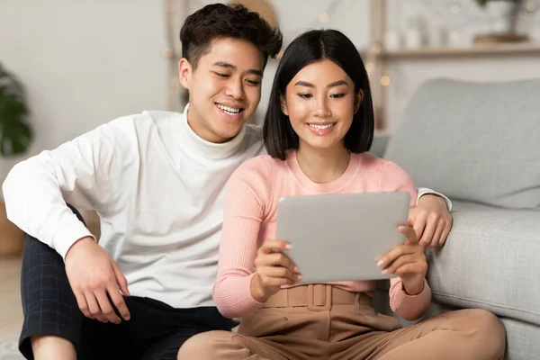 Japanse echtgenoten met behulp van tablet kijken film Online ontspannen thuis — Stockfoto
