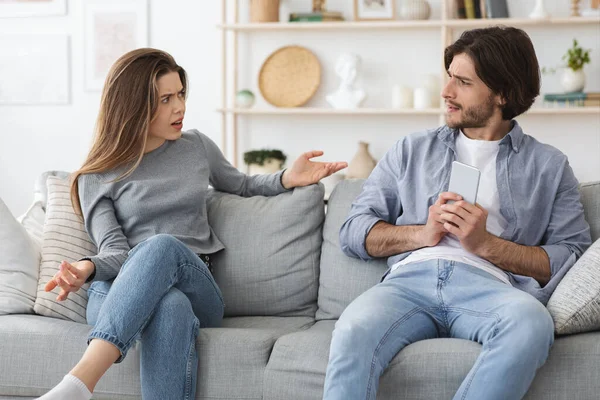 Angry woman yelling at her boyfriend chatting with girl — Stock Photo, Image