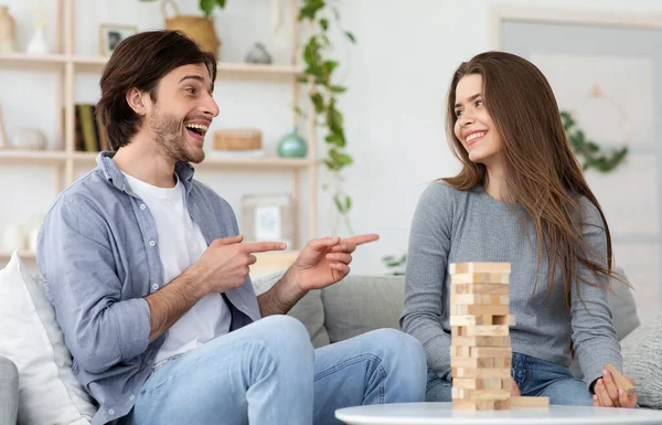 Muž a žena hrají Jenga v obývacím pokoji doma — Stock fotografie