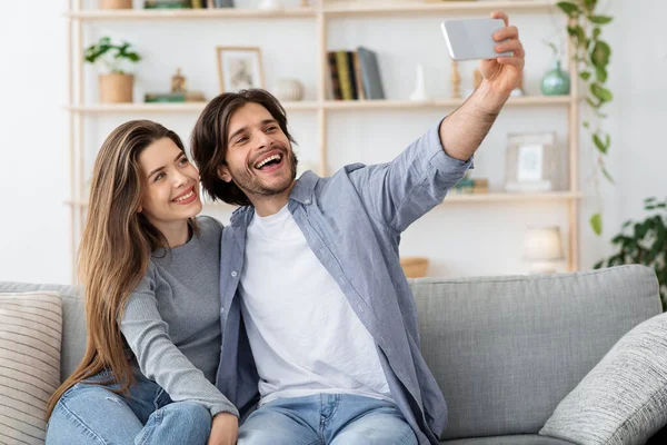 Pareja feliz enamorada tomando selfie en casa —  Fotos de Stock