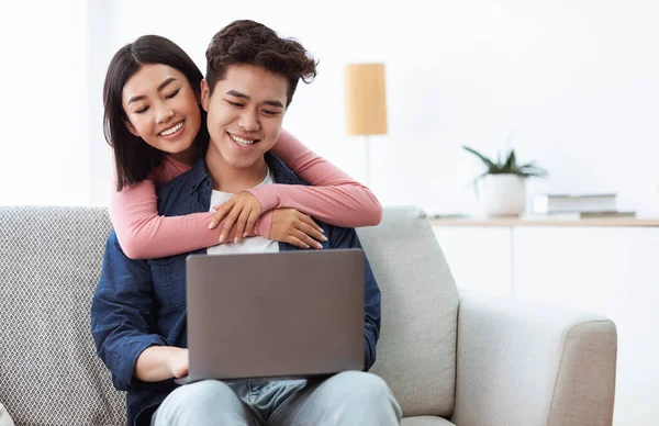 Asijské páry pomocí notebooku relaxační sledování filmu online doma — Stock fotografie