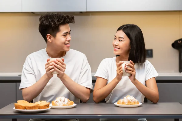 Couple asiatique ayant le petit déjeuner assis dans la cuisine le week-end matin — Photo