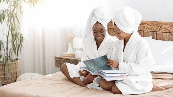 Twee mooie spa dames lezen tijdschrift, slaapkamer interieur — Stockfoto