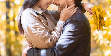 Altın ağaçların üzerinde sarılan bir kadın ve erkek.