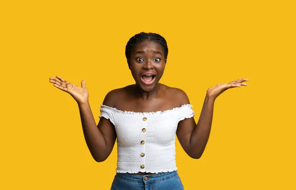 ハッピーショック。興奮をカメラで叫ぶ感情的なアフリカの女性,黄色の背景 — ストック写真