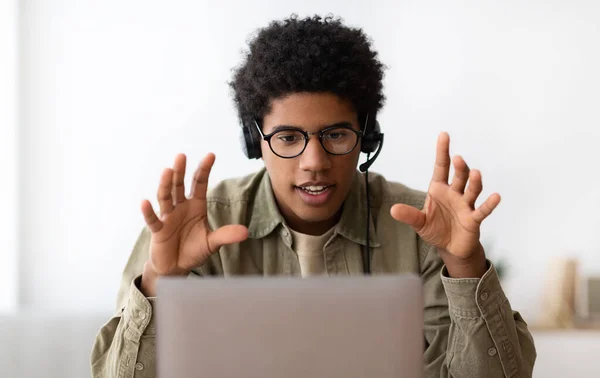Estudante adolescente negro em fones de ouvido assistindo webinar, participando de conferência na web ou aula à distância no laptop — Fotografia de Stock
