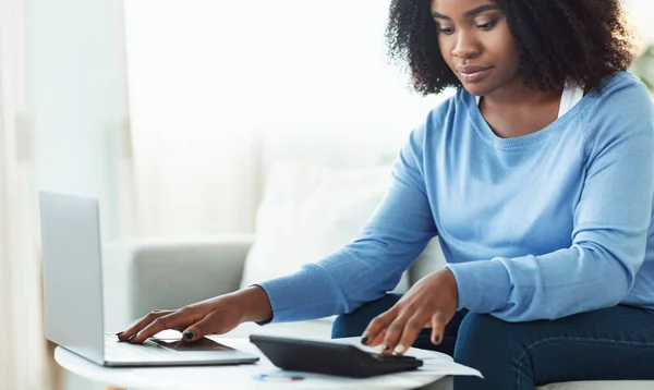 Mujer usando calculadora y ordenador portátil PC en casa — Foto de Stock