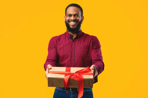 Gelukkig Afrikaans man met geschenkdoos in de studio — Stockfoto