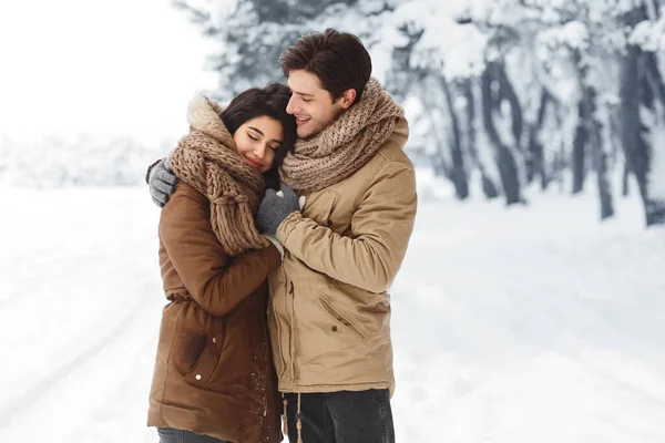 Söta par kramas stående i snöig skog promenader utomhus — Stockfoto