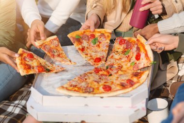 Uluslararası arkadaş grubu pizza alıyor.