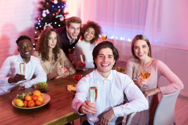 Arkadaşlar ellerinde şampanya bardakları, evde oturmuş kadeh kaldırıyorlar.