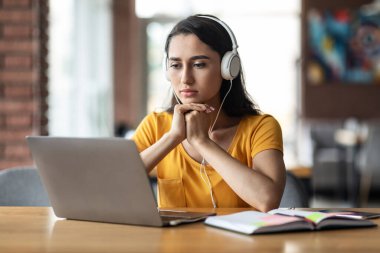 Yoğunlaşmış genç Arap bayan çevrimiçi eğitim kursu alıyor.