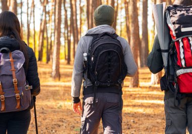 Ormanın yanından geçen üç yürüyüşçünün yakınına.