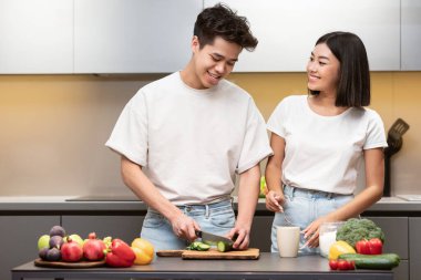 Neşeli Koreli eşler Mutfakta sebze salatası hazırlıyor