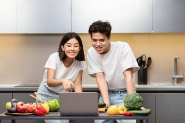 Asyalı Çiftler Mutfakta Dizüstü bilgisayar Tarifi Kullanıyor